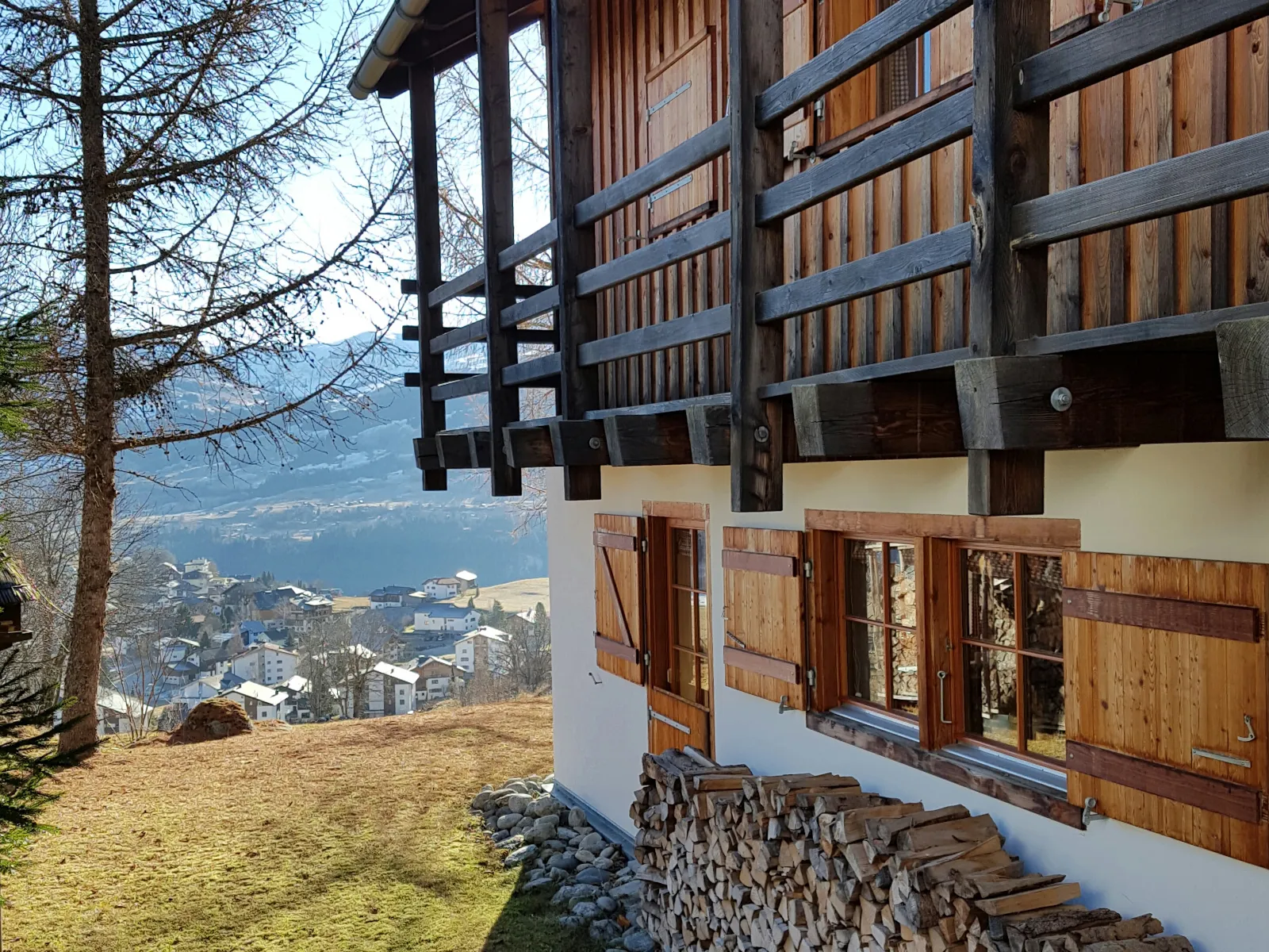 Blick vom Holzbalkon der Casa Seglias über die Dächer von Brigels ins Tal